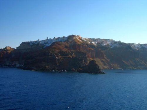 Sunrise over Santorini illuminates the cliffside villages, clinging like a dusting of white frosting on the volcanic rock. Sunrise over Santorini illuminates the cliffside villages, clinging like a dusting of white frosting on the volcanic rock.